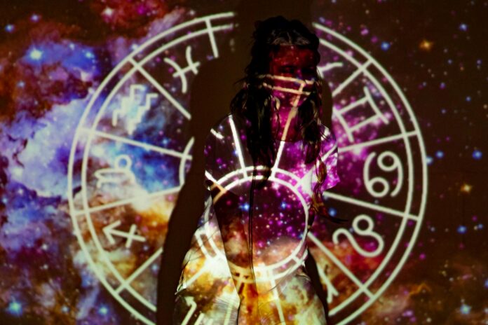 woman standing in front of galaxy projection